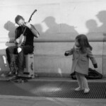 A banjo player and a little girl dancing